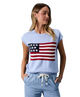 Woman wearing a light blue sweater with an American flag design on a white background