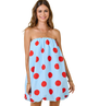 Woman wearing a light blue dress with red polka dots on a white background