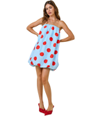 Woman wearing a strapless dress with red polka dots on a white background