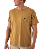 Man wearing a light brown t-shirt with a brand logo on a white background