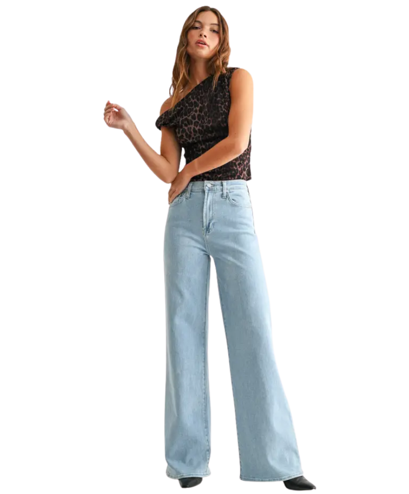 Woman wearring light denim pants with a high rise and wide leg