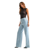 Woman wearring light denim pants with a high rise and wide leg