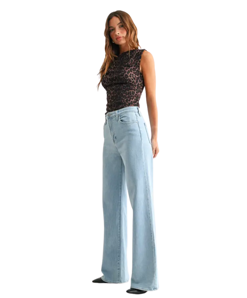 Woman wearring light denim pants with a high rise and wide leg