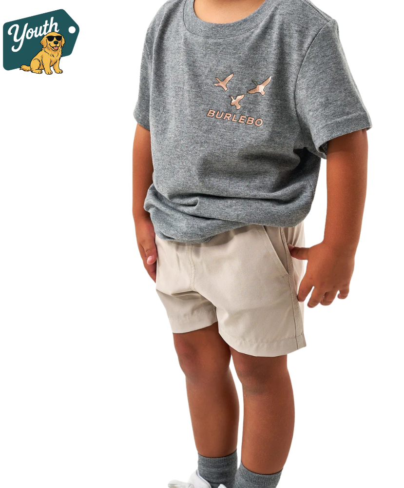 Child wearing a gray t-shirt with 'Burlesco' logo and beige shorts on a white background.
