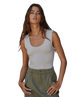 Woman wearing a white tank top and green pants on a white background