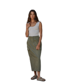 Woman wearing a white tank top and green cargo pants on a white background