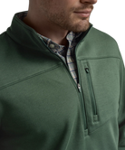 Green pullover with a plaid shirt underneath on a white background