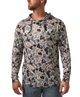 A man wearing a long-sleeve camouflage hoodie in shades of gray, beige, and black, paired with blue jeans, shown from the waist up against a plain white background.