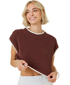 Woman wearing a brown knitted top with white trim on a white background