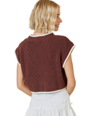 Woman wearing a brown knitted vest with white trim on a white background