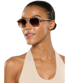 Woman wearing tortoiseshell Krewe sunglasses on a white background
