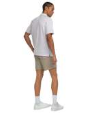 Man wearing a striped polo shirt and beige shorts on a white background