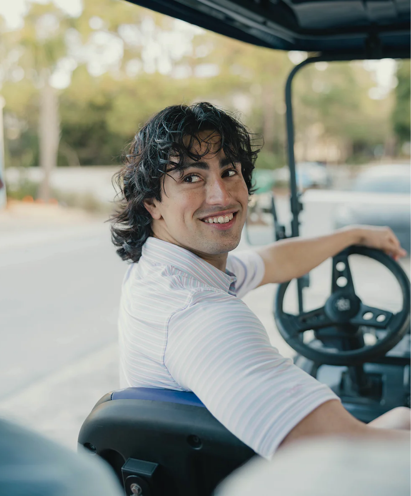 Man sitting in a golf cart with a blurred background
