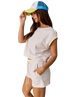 Woman wearing a white outfit with a colorful cap on a white background