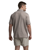 Man wearing a striped polo shirt and beige shorts on a white background
