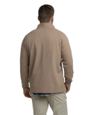 Man wearing a light brown long-sleeve quarter-zip pullover on a white background