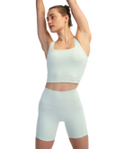 Woman wearing a light blue athletic outfit on a white background
