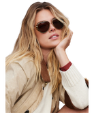 Woman wearing Krewe sunglasses with a neutral background