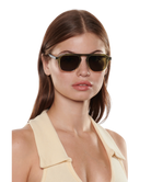 Woman wearing Krewe sunglasses with a plain background