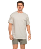 Man wearing a IVORY t-shirt with a CAMO dog graphic on the back, standing against a white background