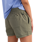 woman wearing olive green shorts on a white background