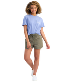 Woman wearing a light blue t-shirt and green shorts on a white background