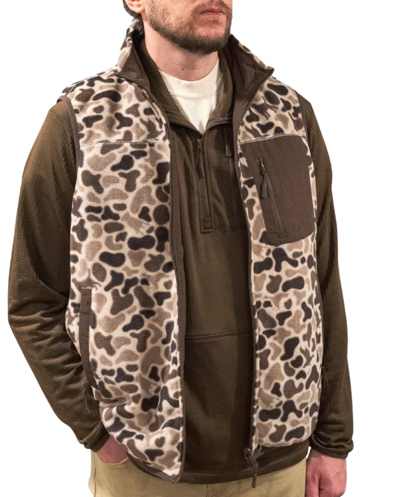 Man wearing a brown jacket with a camouflage vest over it on a white background