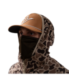 Person wearing a camouflage hooded jacket and brown cap on a white background