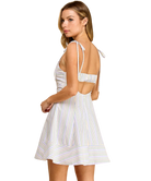 Woman wearing a white striped dress with thin straps on a white background