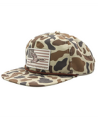 Camouflage-patterned cap with an American flag patch featuring an eagle on a white background