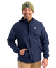 Man wearing a HUK navy jacket with a brand logo on a white background