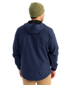 Man wearing a HUK navy jacket with a brand logo on a white background