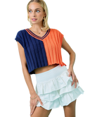 Woman wearing a colorful cropped top and white ruffled skirt on a white background AUBURN