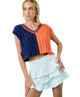 Woman wearing a colorful cropped top and white ruffled skirt on a white background AUBURN