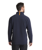 Man wearing a navy blue pullover quarter zip jacket with an orange zipper on a white background