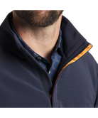 Man wearing a navy blue pullover with a white background