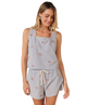 Woman wearing a light blue sleeveless top and shorts with small USA flag patterns on a white background