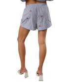 Person wearing blue STRIPED shorts with american flags on a white background