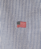 Close-up of a blue and white striped fabric with an embroidered American flag.