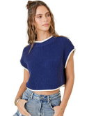 Woman wearing a blue ribbed crop top with white trim on a white background