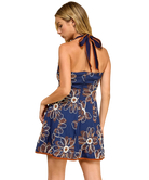 Woman wearing a blue floral dress with a halter neck design on a white background