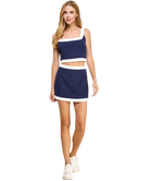 Woman wearing a navy and white outfit on a white background