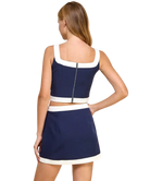 Woman wearing a navy and white dress on a white background