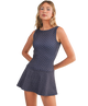Woman wearing a navy dress with white polka dots on a white background