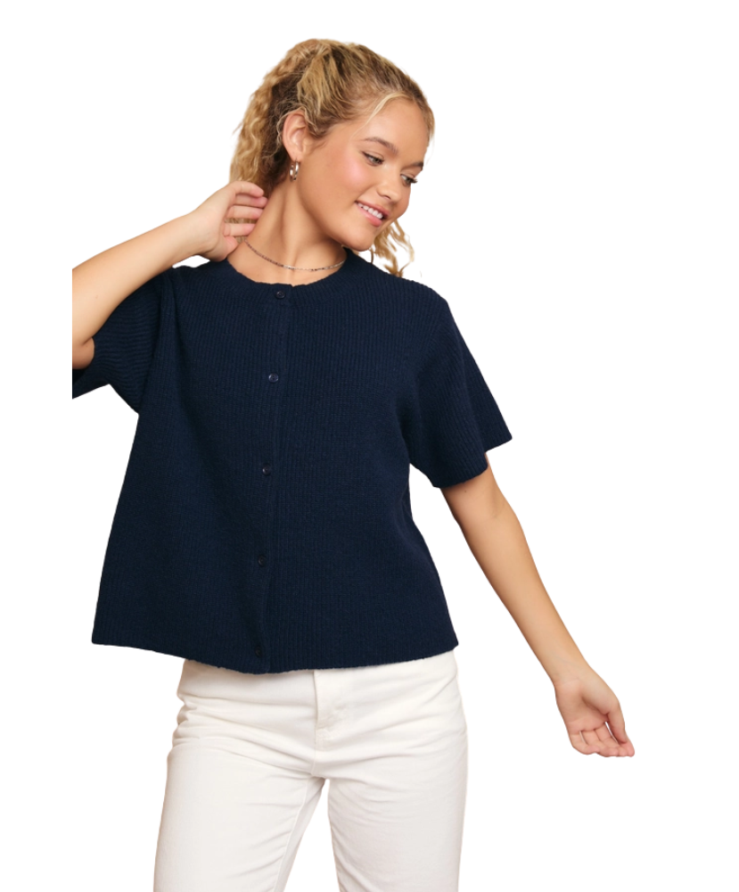 Woman wearing a navy blue shirt and white pants on a white background