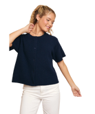 Woman wearing a navy blue shirt and white pants on a white background