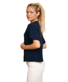 Woman wearing a navy blue sweater and white pants on a white background