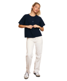 Person wearing a navy blue shirt and white pants on a white background