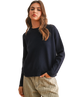 Woman wearing a navy sweater and plaid pants on a white background
