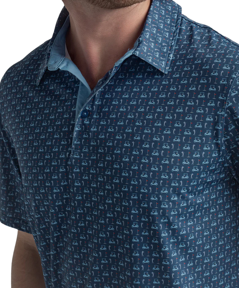 Man wearing a blue golf cart patterned polo shirt and beige shorts on a white background